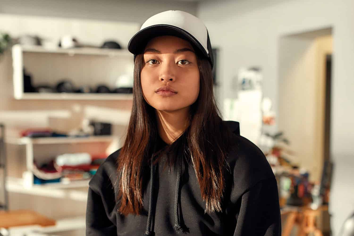 Young woman in baseball cap and hoody.