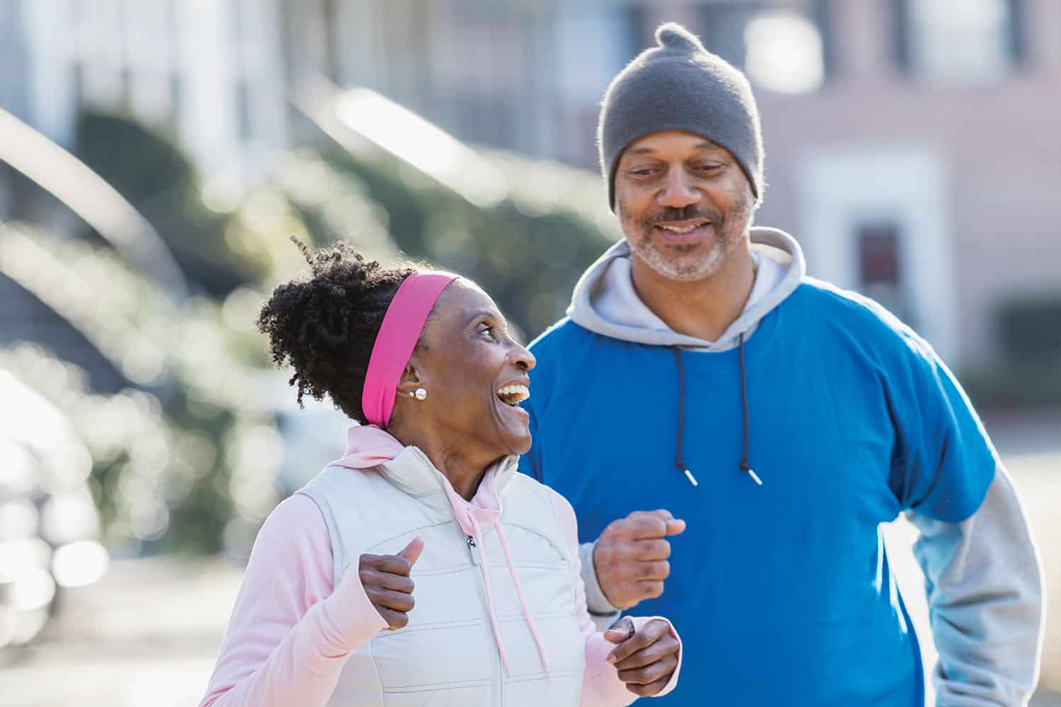 Older woman and man out jogging and smiling.
