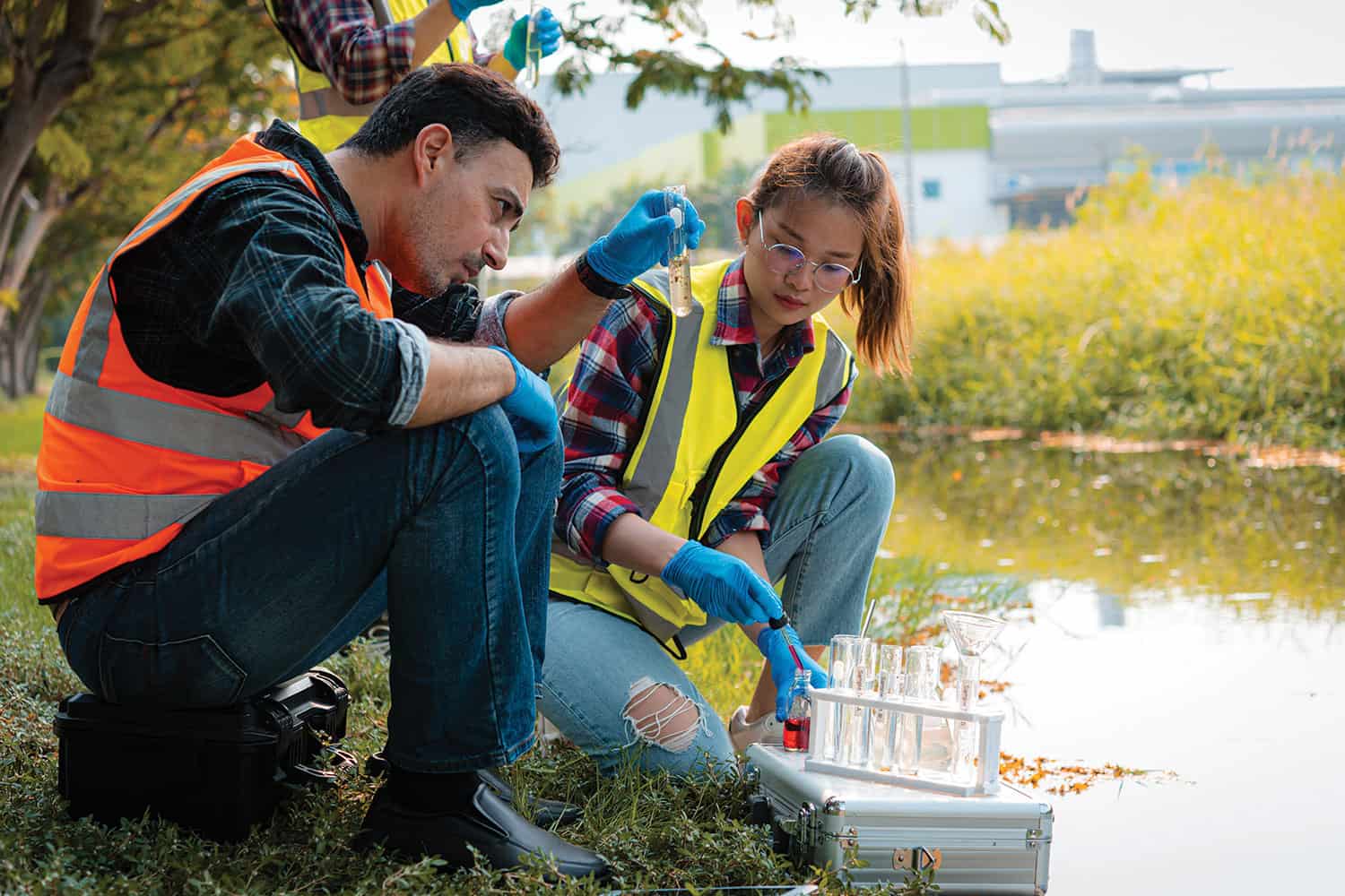 male and female apprentice taking water samples from river