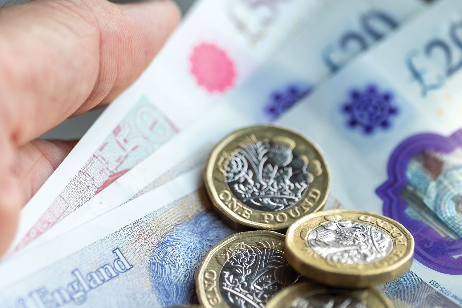 photo of UK pound coins sitting on UK bank notes