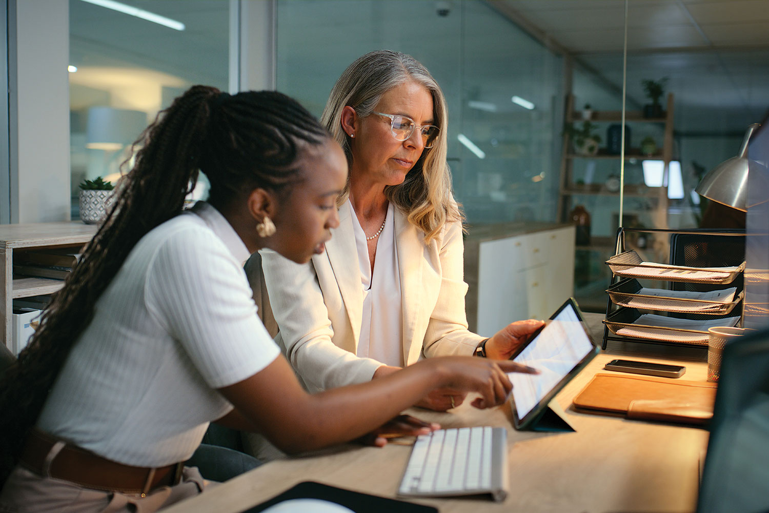 older professional woman training younger woman in office setting
