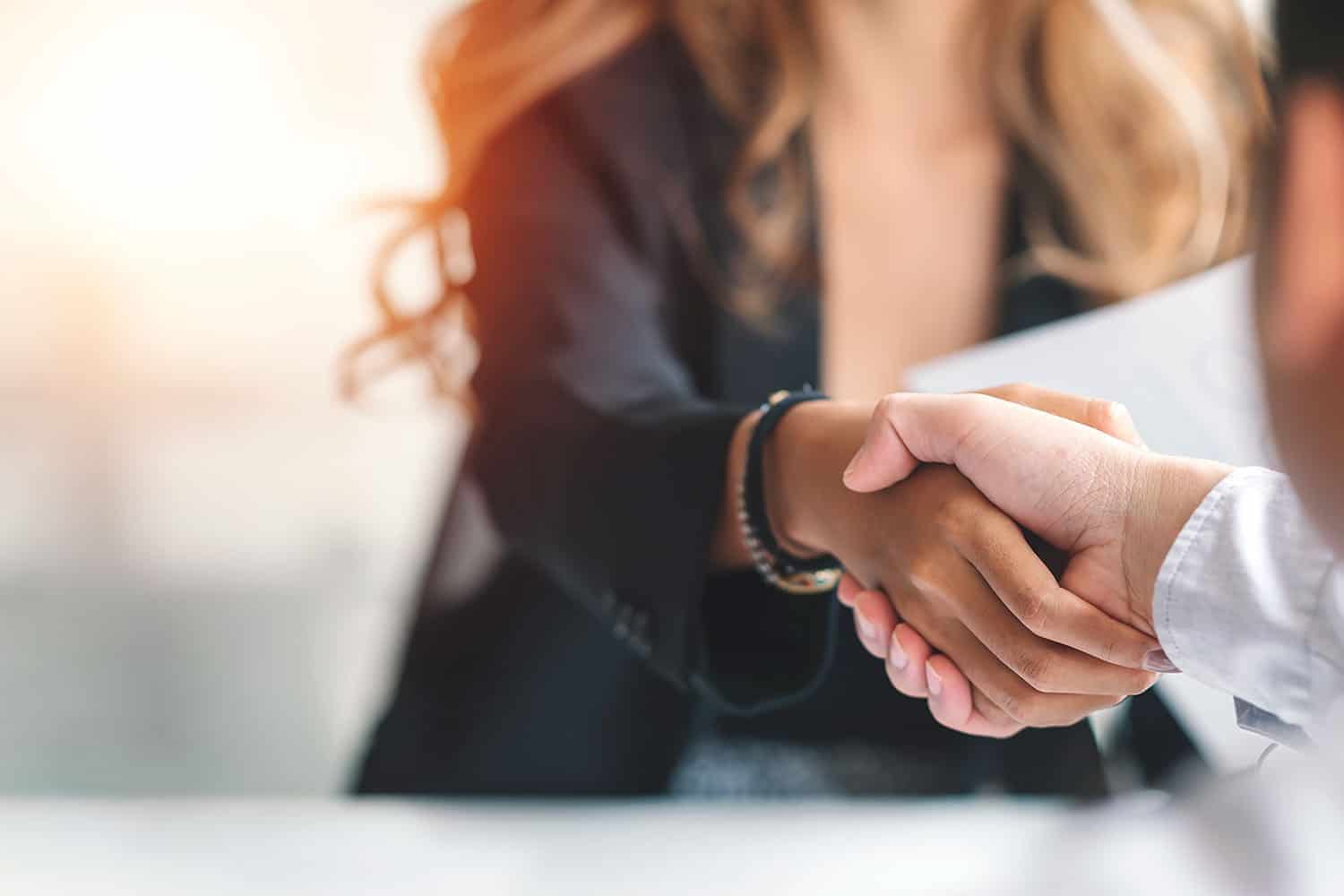close-up of businessman and woman shaking hands